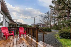 two red chairs sitting on a wooden deck at Barefoot Bungalow in Seaside