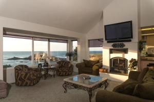 a living room with a fireplace and a tv at Pirate's Cove in Depoe Bay