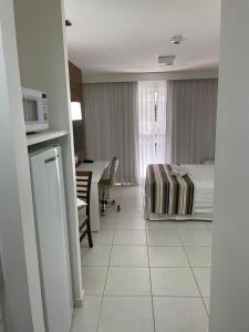 um quarto de hotel com uma cama e uma mesa com um micro-ondas em FLAT FUSION em Brasília