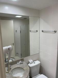 uma casa de banho com um WC, um lavatório e um espelho. em FLAT FUSION em Brasília