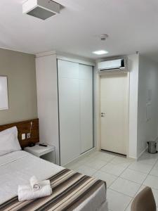 a bedroom with a bed and a sliding glass door at FLAT FUSION in Brasilia