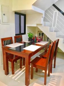 - une salle à manger avec une table et des chaises en bois dans l'établissement The Ideal Place in Cauayan city, à Cauayan