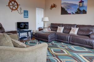 a living room with a brown leather couch and a rug at Bay Echo in Depoe Bay