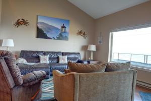 a living room with couches and a couch and a window at Bay Echo in Depoe Bay