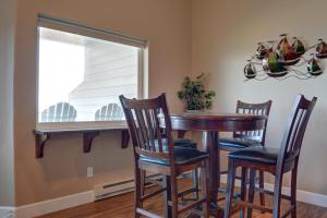 a dining room table with three chairs and a window at Bay Echo in Depoe Bay
