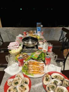 uma mesa coberta com pratos de comida e sanduíches em Doc Ba Tang em Lai Sơn