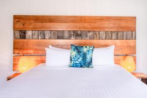 a bedroom with a white bed with a wooden headboard at Whale Watcher 2 in Coles Bay