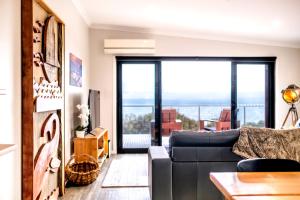 a living room with a couch and a large window at Whale Watcher 2 in Coles Bay