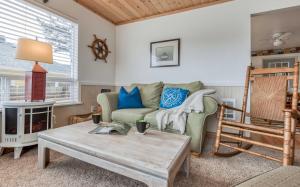 a living room with a couch and a table at Brass Bell Cottage in Rockaway Beach