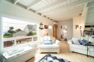 a living room with white furniture and a large window at Coral Cottage in Depoe Bay