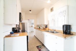 a kitchen with white cabinets and a stainless steel refrigerator at Coral Cottage in Depoe Bay