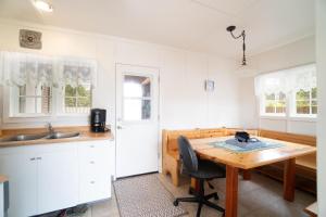 a kitchen with a wooden table and a kitchen with white cabinets at Coral Cottage in Depoe Bay +124 photos