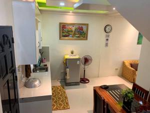 a living room with a refrigerator and a clock on the wall at The Ideal Place in Cauayan city in Cauayan City