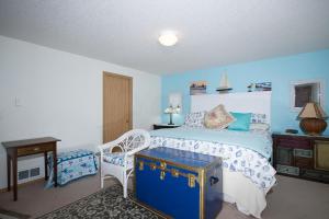 a bedroom with a bed and a table and a chair at Family Tides in Seaside in Seaside