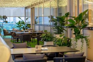 杭州杭州临平皇冠假日酒店的有桌椅和植物的餐厅