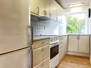a kitchen with white appliances and a window at Lovely Two Story House in Odense