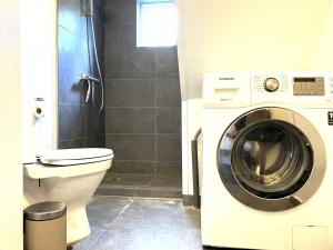 a bathroom with a washing machine and a toilet at Lovely Two Story House in Odense