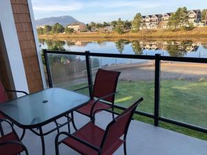een tafel en stoelen op een balkon met uitzicht op een meer bij Riverview Retreat in Seaside