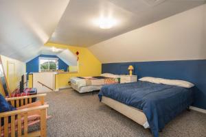a bedroom with two beds and a blue and yellow wall at Easy Street in Rockaway Beach
