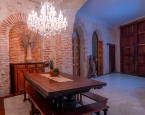 a dining room with a table and a chandelier at Amara Living in Cartagena de Indias