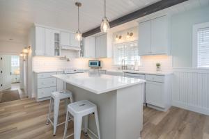 a kitchen with white cabinets and a large island at Hydrangea House in Seaside