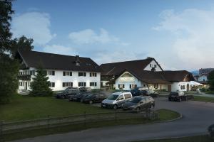 un groupe de voitures garées devant un bâtiment dans l'établissement Hotel Oedhof, à Freilassing