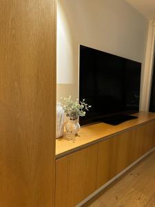 a entertainment center with a large flat screen tv at Palko - Stylish in the City in Canberra