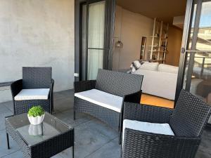 eine Terrasse mit Stühlen, einem Tisch und einem Sofa in der Unterkunft Palko - Oasis in the City in Canberra