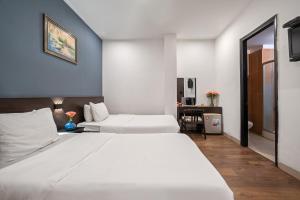 Postel nebo postele na pokoji v ubytování Gold Time Hotel Da Nang