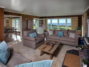 a living room with two couches and a table at Estuary Cottage in Seaside