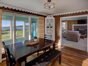 a dining room with a table and a living room at Estuary Cottage in Seaside