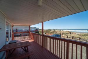 a porch with a bench and a view of the beach at Getaway Oceanfront Lodging in Rockaway Beach