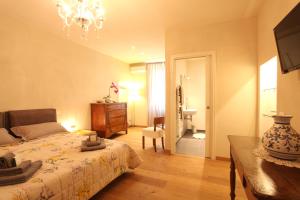 a bedroom with a bed and a table and a chandelier at B&B Antico Cancello in Lucca