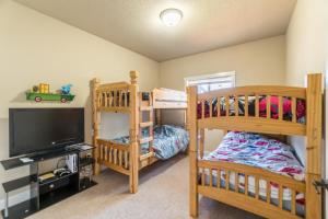 a bedroom with two bunk beds and a flat screen tv at Family Tides in Lincoln City