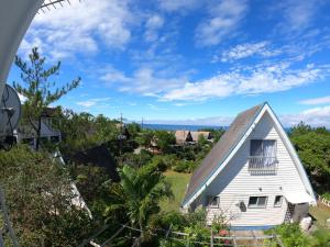 an old white house with a gambrel roof at にらい恩納　杉の木 in Onna