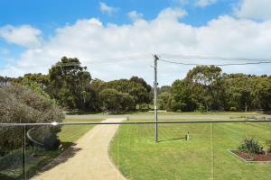 a tennis court in a park with trees at Rolling Waves in Pt Leo in Shoreham