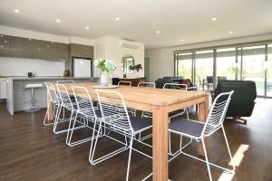 a kitchen and dining room with a wooden table and chairs at Rolling Waves in Pt Leo in Shoreham
