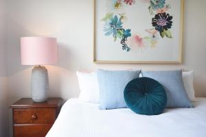 a bed with a blue heart pillow on top of it at Rolling Waves in Pt Leo in Shoreham