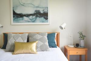 a bedroom with a bed with blue and white pillows at Rolling Waves in Pt Leo in Shoreham