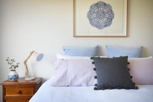 a bedroom with a bed with blue and white pillows at Rolling Waves in Pt Leo in Shoreham