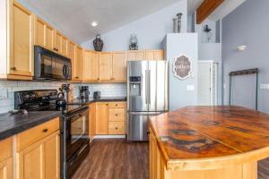 a kitchen with wooden cabinets and a stainless steel refrigerator at Serendipity by the Sea in Pacific City