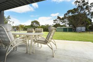 a table and chairs on a patio with a park at Rolling Waves in Pt Leo in Shoreham
