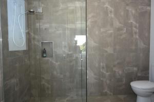 a bathroom with a glass shower with a toilet at Rolling Waves in Pt Leo in Shoreham +15 photos