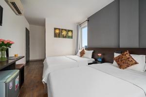 Postel nebo postele na pokoji v ubytování Gold Time Hotel Da Nang