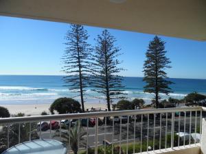 a balcony with a view of the beach and trees at Coolum Caprice in Coolum Beach