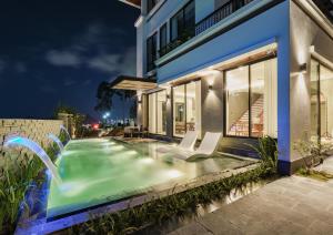uma piscina ao lado de um edifício à noite em Villa FLC Hạ Long bt3-6 em Ha Long