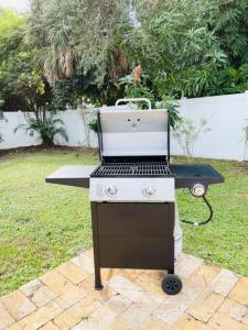 a barbecue grill sitting on top of a lawn at Tropical Oasis House Private Pool Family Yard in Fort Lauderdale