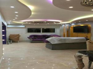 un soggiorno con mobili viola e soffitto di Alnahas St. Two-Bedroom Apartment With Jacuzzi a Tanta