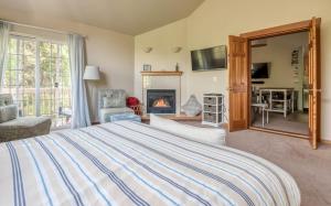 a bedroom with a large bed and a fireplace at Tolovana #3 in Cannon Beach