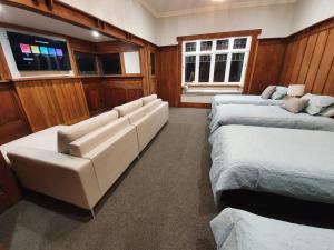 a room with two beds and a couch and a tv at Tauranga - Big, beautiful Villa on the water! in Tauranga